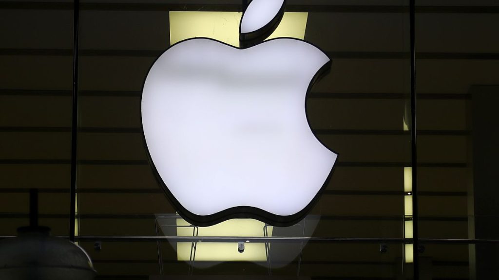 The Apple logo is illuminated at a store in the city center of Munich, Germany, Dec. 16, 2020.