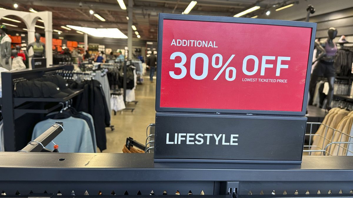 A sign trumpets the discounts available on items in a sports apparel store in the Thornton Premium Outlets Monday, Dec. 18, 2023, in Thornton, Colo.