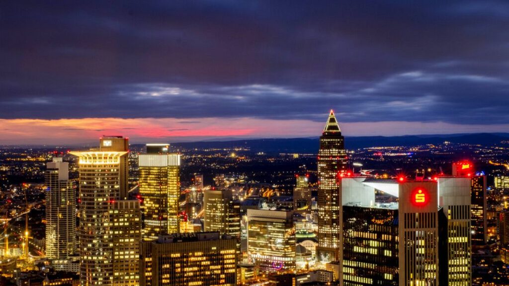 In this Friday, Feb 14, 2020 file photo, the buildings of the banking district are seen after the sun set in Frankfurt, Germany.