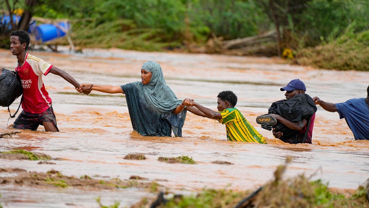 Residents cross a road damaged by El Niño rains in Tula, Tana River county in Kenya on 25 November 2023.