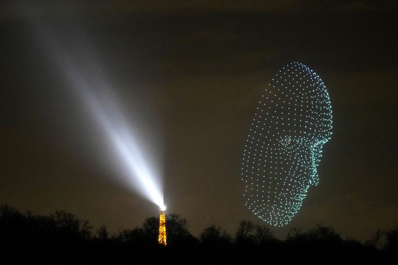 Un drone lumineux survole près de la Tour Eiffel à Paris, décembre 2023