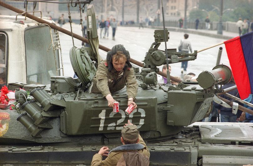 Un soldat donne deux canettes de Coca-Cola à son ami chauffeur de char près du bâtiment de la Fédération de Russie à Moscou, août 1991.