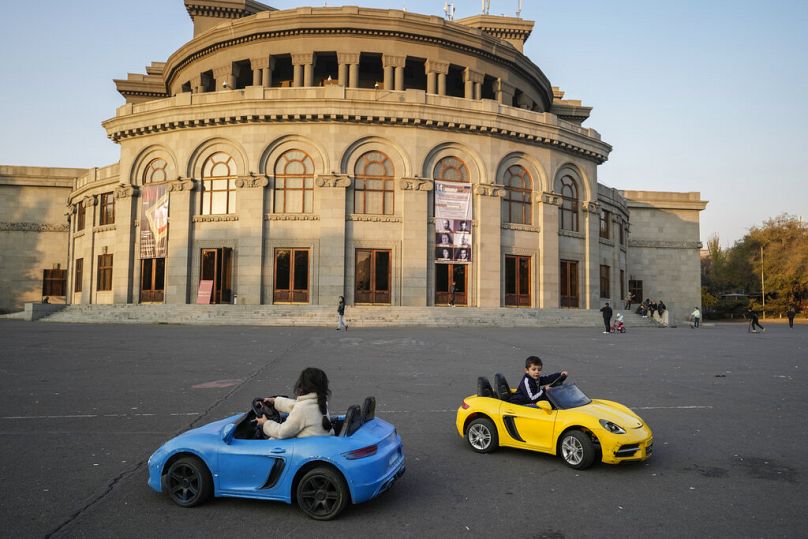 Des enfants conduisent des voitures miniatures sur la Place de la Liberté à Erevan, en novembre 2021