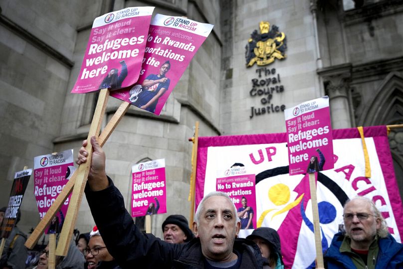 Des militants de Stand Up To Racism brandissent des banderoles devant la Haute Cour de Londres, décembre 2022.