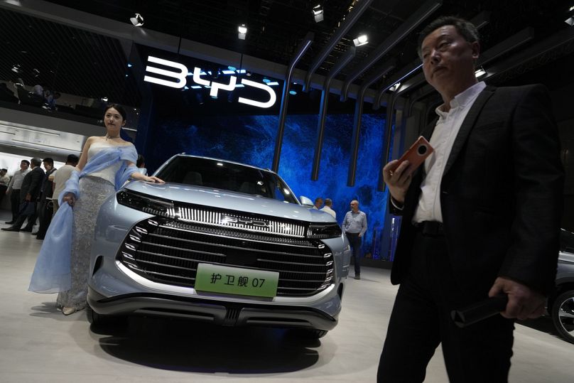 Un mannequin se tient à côté d'une voiture BYD lors du salon de l'auto de Shanghai, en avril 2023.