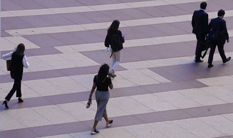 Des femmes marchent vers un immeuble de bureaux à Madrid, mai 2022