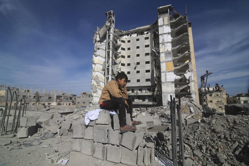 Un garçon palestinien est assis devant un immeuble résidentiel détruit lors d’une frappe israélienne à Rafah, dans la bande de Gaza, le samedi 9 mars 2024.