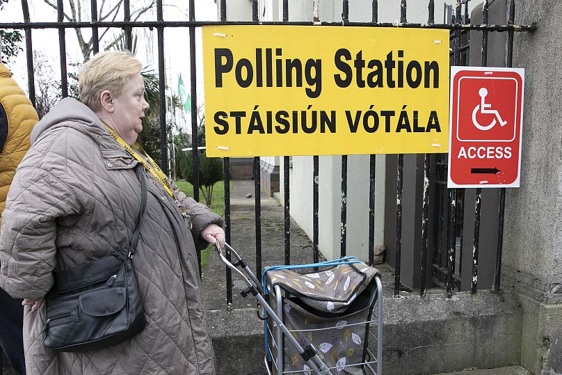 Une femme arrive pour voter lors d'un référendum sur les modifications proposées au libellé de la Constitution relative aux domaines de la famille et des soins.