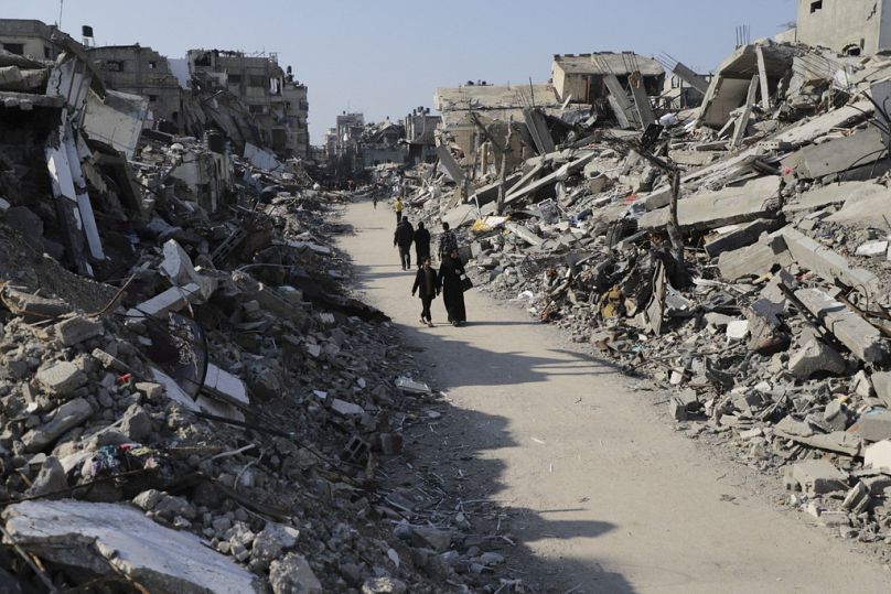 Des Palestiniens traversent les destructions causées par l'offensive israélienne dans le camp de réfugiés de Jabaliya, dans la bande de Gaza, le jeudi 29 février 2024.
