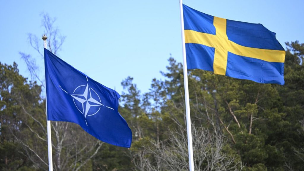 The NATO flag, left, is raised next to the Swedish flag during a ceremony at the Musko navy base Stockholm, Monday, March 11, 2024.