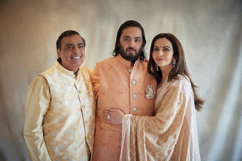 L'industriel milliardaire Mukesh Ambani, son fils Anant et sa femme Nita, posant pour une photo alors que les invités se rassemblent pour célébrer le mariage d'Anant à Jamnagar, en Inde.