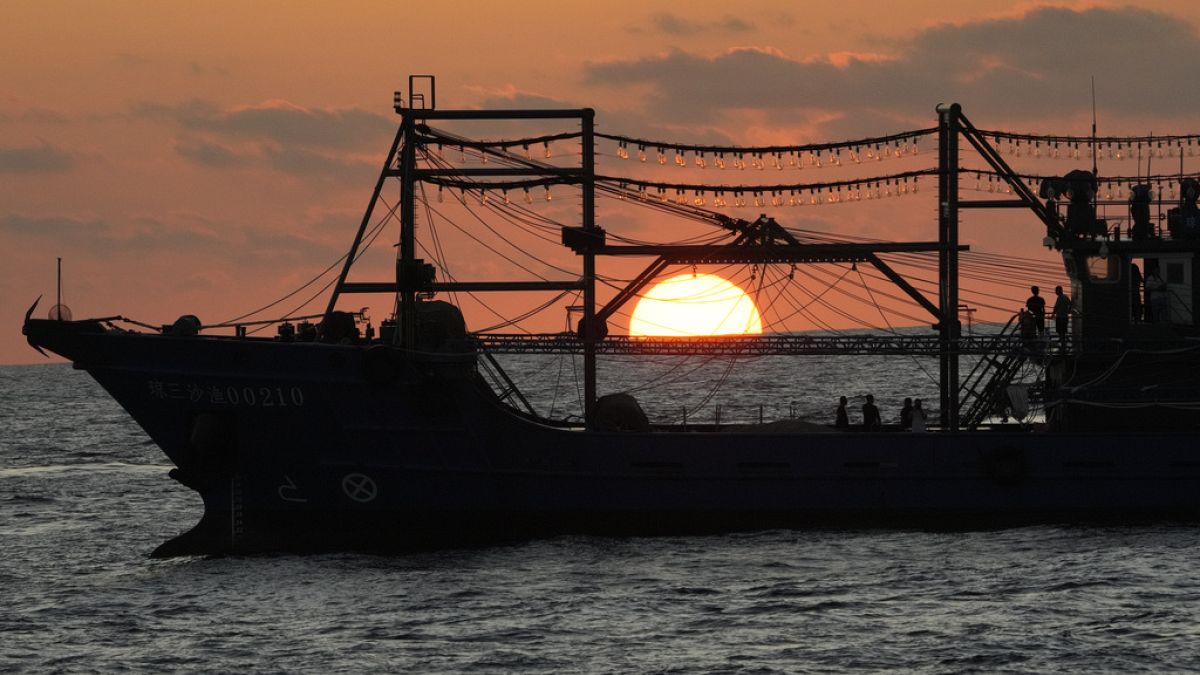 The sun rises while a suspected Chinese militia ship blocks Philippine coast guard ship, not shown, in the disputed South China Sea Tuesday, March 5, 2024.