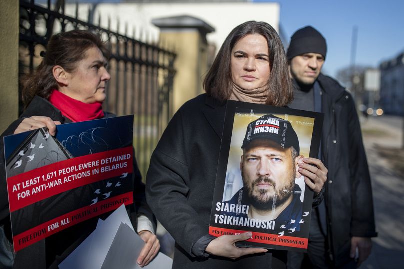 La chef de l'opposition biélorusse Sviatlana Tsikhanouskaya tient un portrait de son mari emprisonné Syarhey Tsikhanousky participant à une manifestation réclamant la liberté des prisonniers politiques