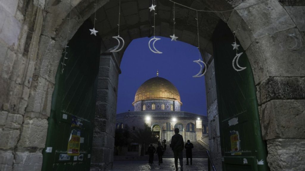 Muslims walk next to the Dome of Rock Mosque at the Al-Aqsa Mosque compound in Jerusalem