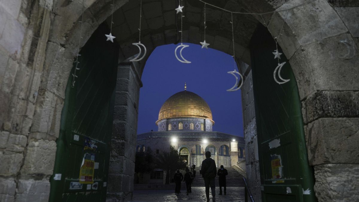 Muslims walk next to the Dome of Rock Mosque at the Al-Aqsa Mosque compound in Jerusalem