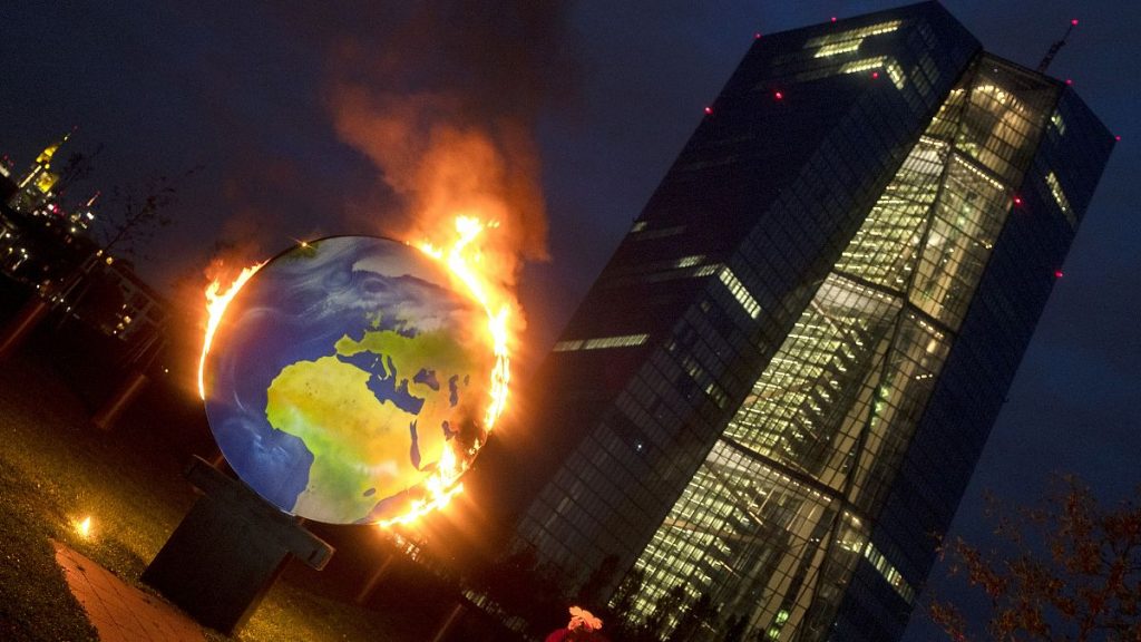 A makeshift globe burns in front of the ECB in Frankfurt, Germany, as activists protest against the bank