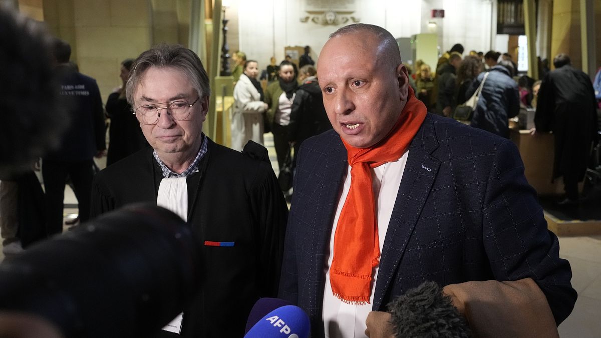 Taxi driver Mostafa Salhane, right, answers journalists with his lawyer Claude Lienard at the Paris