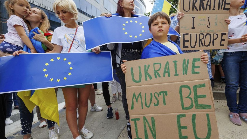 Protestors hold signs and EU and Ukrainian flags during a demonstration in support of Ukraine outside of an EU summit in Brussels, on June 23, 2022.