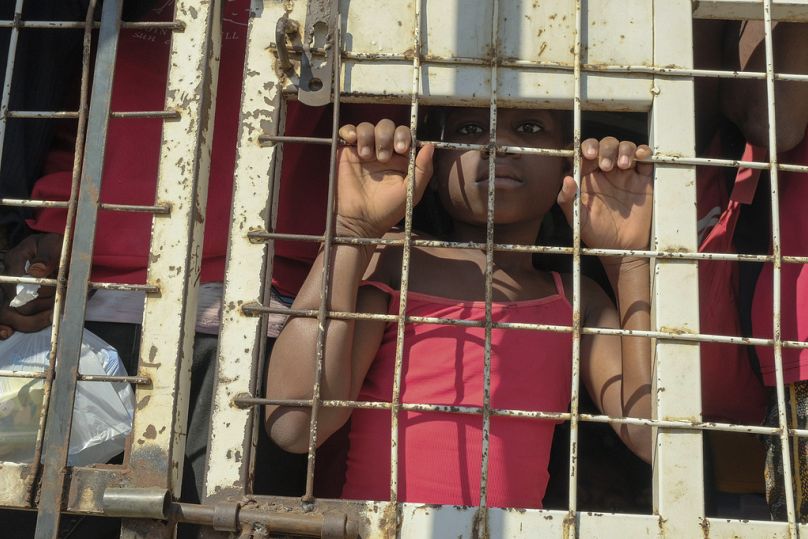 Un enfant se tient au milieu de personnes arrêtées pour être expulsées vers Haïti à l'intérieur d'un camion de police sur un pont frontalier qui relie Dajabon, en République dominicaine, à Haïti, le 18/03/24.