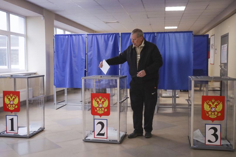 Un homme vote dans un bureau de vote lors d'une élection présidentielle à Marioupol, dans la région de Donetsk occupée par la Russie, dans l'est de l'Ukraine.