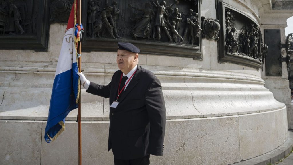 A protester hold a French flag during a pro police demonstration, on Republique square, in Paris, Saturday, Sept. 30, 2023.