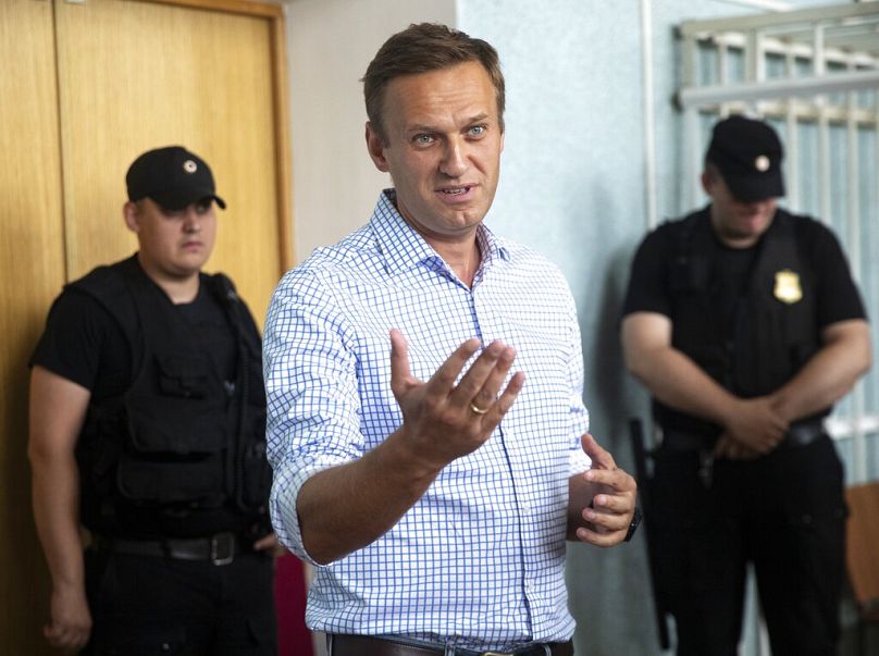 Le militant de l'opposition russe Alexei Navalny, à gauche, fait des gestes devant un tribunal avant une audience à Moscou, en Russie, le lundi 1er juillet 2019.