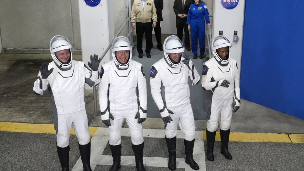 Four astronauts wave to the media as they leave the Operations and Checkout building for a trip to Launch Pad 39-A, Sunday, March 3, 2024