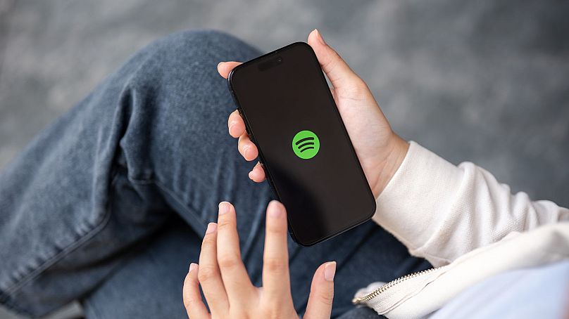 Une femme utilisant l'application Spotify sur son smartphone à l'extérieur