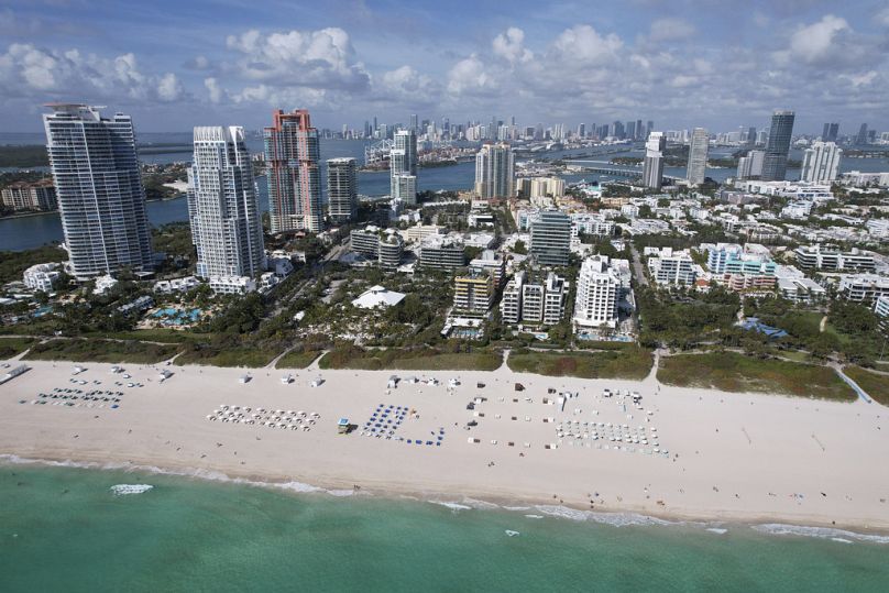 Des chaises parsèment la large plage de sable, dans le quartier de South Beach à Miami Beach