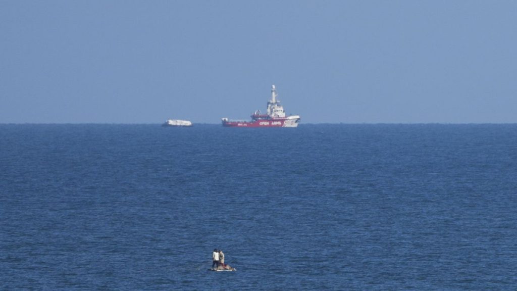 A ship belonging to the Open Arms aid group approaches the shores of Gaza towing a barge with 200 tons of humanitarian aid.