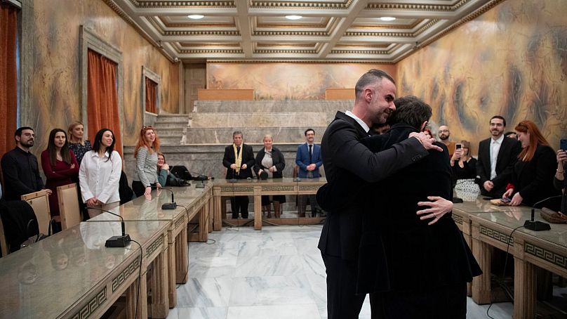 L'avocat Anastasios Samouilidis, à gauche, embrasse son mari, l'auteur grec Petros Hadjopoulos, qui utilise le pseudonyme d'Auguste Corteau, sous les yeux des invités, après leur mariage à Athènes.