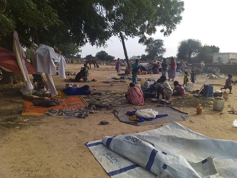 Des habitants déplacés suite à une vague d'attaques violentes sont accroupis sur des couvertures et dans des tentes confectionnées à la hâte dans le village de Masteri, dans l'ouest du Darfour, au Soudan.