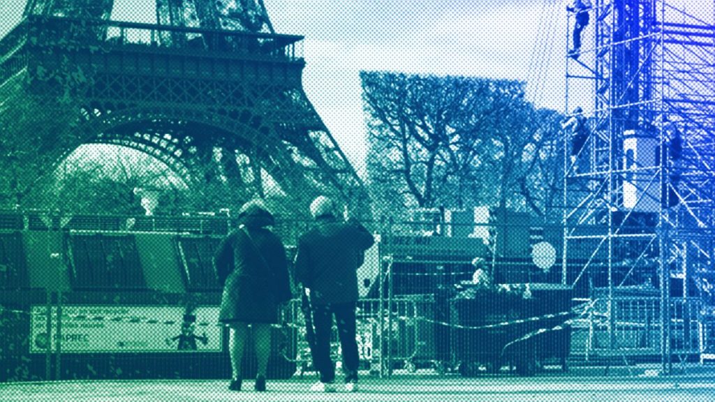 People watch workers building the stands for the upcoming summer Olympic Games on the Champ-de-Mars just beside the Eiffel Tower, in Paris, April 2024