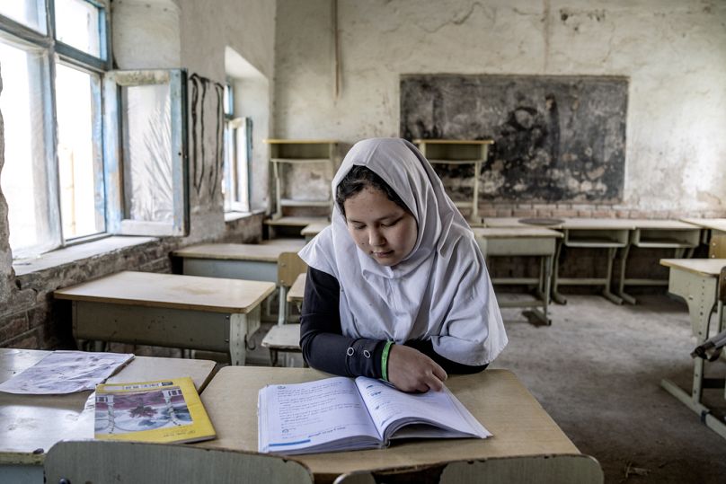 Une fillette lit un livre dans sa classe le premier jour de la nouvelle année scolaire, à Kaboul, en mars 2023.
