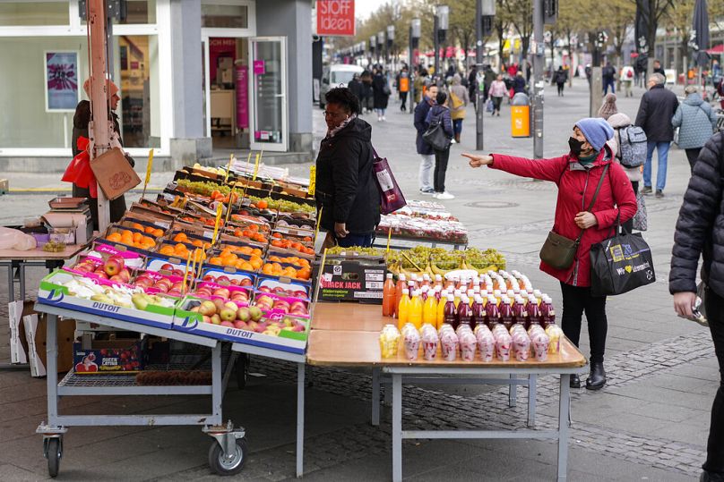 Des gens choisissent des fruits et légumes à acheter dans un marché de rue à Berlin, avril 2022