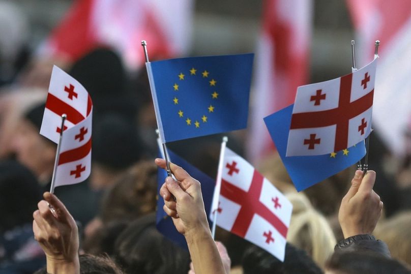 Les Géorgiens brandissent des drapeaux européens et nationaux alors qu'ils se rassemblent pour célébrer la candidature de la Géorgie à l'UE sur la place de la Liberté à Tbilissi, en décembre 2023.