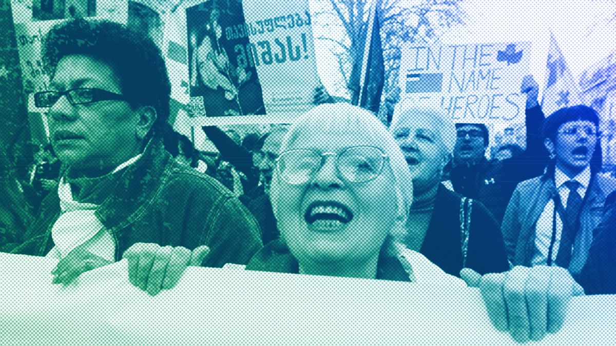 A woman shouts as other protestors march outside the parliament building in protest of