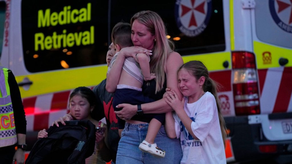 People are led out from the Westfield Shopping Centre where multiple people were stabbed in Sydney, Saturday, April 13, 2024.