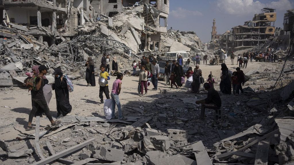 Palestinians walk through the destruction in the wake of an Israeli air and ground offensive in Khan Younis, southern Gaza Strip, April 8, 2024.