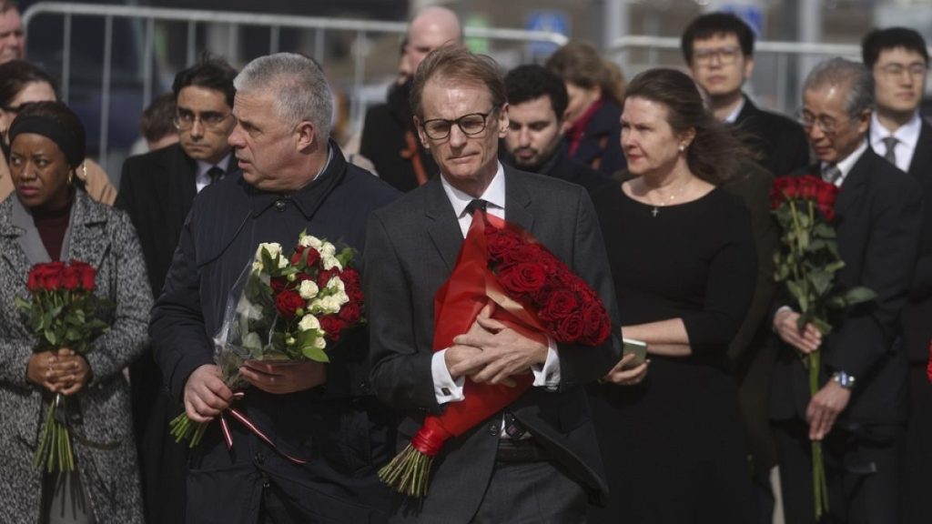 British Deputy Head of Mission to Russia Tom Dodd, center, with other ambassadors of foreign diplomatic missions, attends a flower-laying ceremony in front of Crocus City Hall