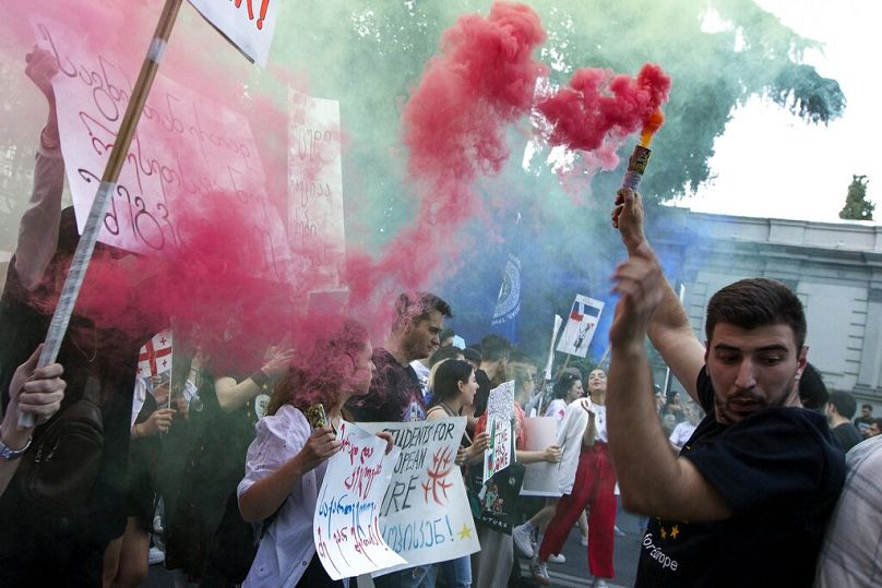 Un manifestant brandit une fusée éclairante lors d'un rassemblement pro-UE et anti-gouvernemental devant le Parlement géorgien à Tbilissi, juillet 2022.