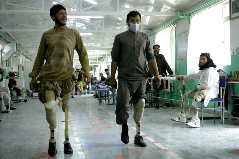 Des Afghans ayant perdu leurs jambes à cause de mines terrestres apprennent à utiliser leurs nouvelles prothèses au centre du CICR à Kaboul, mai 2022.