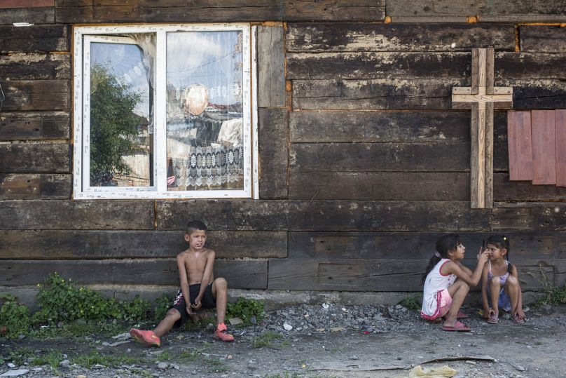 Des enfants se reposent à l’ombre d’un mur d’église dans un quartier rom de la banlieue d’Uzhgorod, juin 2018.