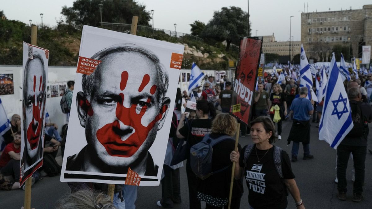 People take part in a protest against Israeli Prime Minister Benjamin Netanyahu