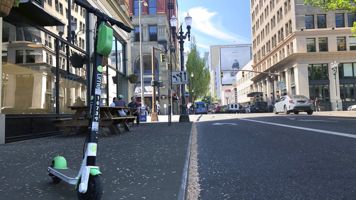 A Lime e-scooter sits parked on a street in downtown Portland, Ore., Thursday, May 9, 2019.