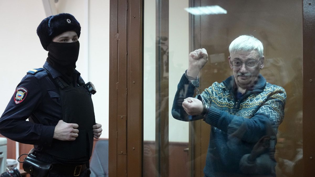 The co-chair of the Nobel Peace Prize winning Memorial Human Rights Centre Oleg Orlov gestures standing in a glass cage after he was taken into custody in the courtroom,Feb 23