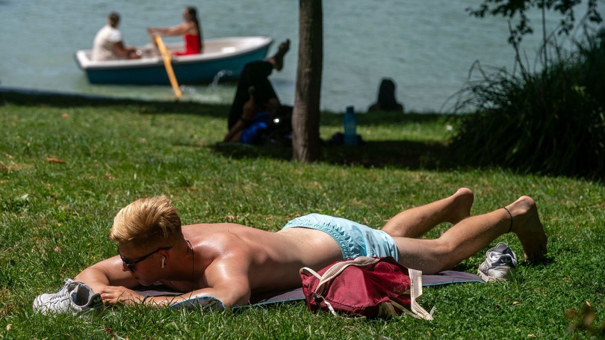 A young man sunbathes in Madrid, Spain, during scorching temperatures in August 2021.