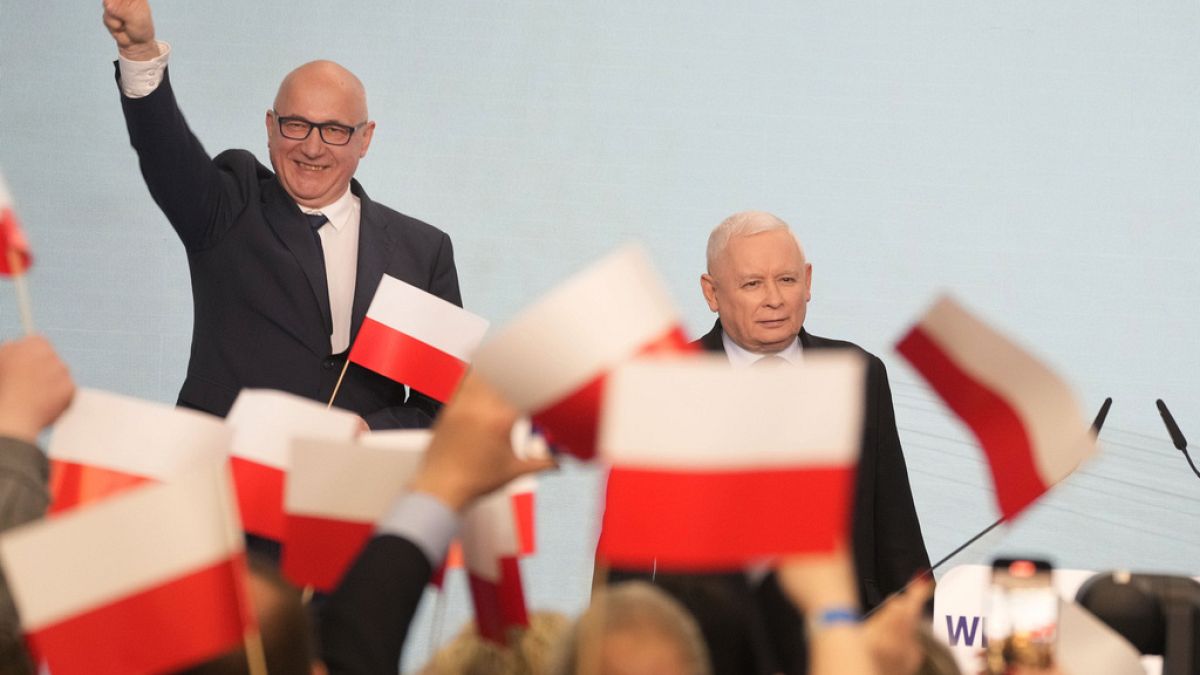 Conservative Law and Justice party leader Jaroslaw Kaczynski, right, joins supporters during Poland