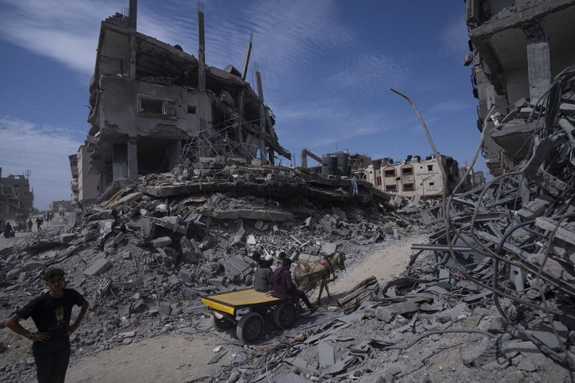 Des Palestiniens traversent les destructions consécutives à une offensive aérienne et terrestre israélienne à Khan Younis, dans le sud de la bande de Gaza, le lundi 8 avril 2024.
