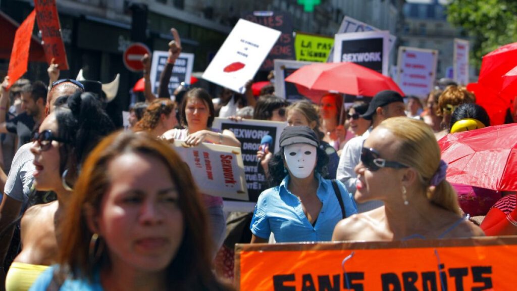 A French sex worker holds a banner reading